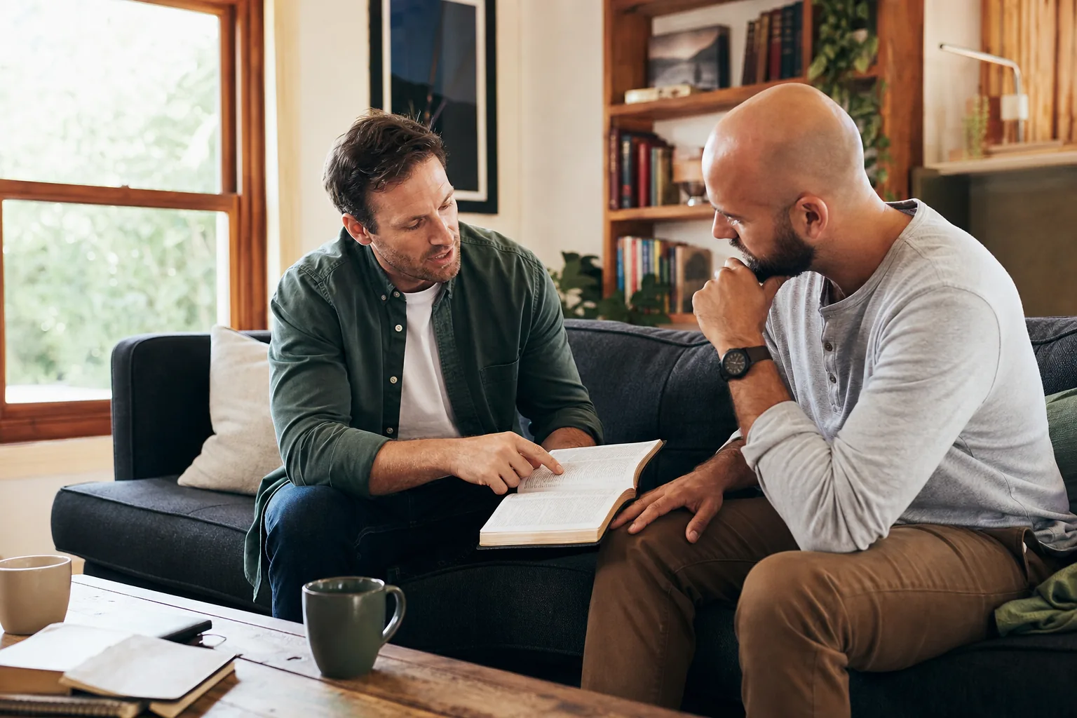 Two friends having an honest conversation while reading an open Bible together